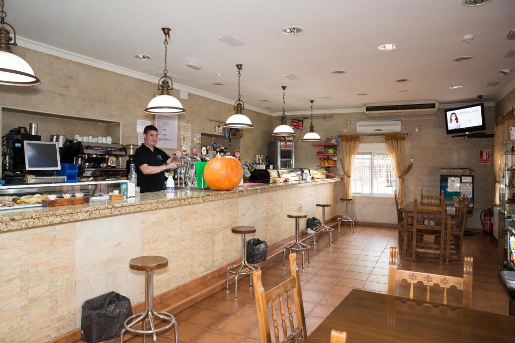 a man standing at a bar in a restaurant at Hostal El Rincón - Casa Marcos in Yepes