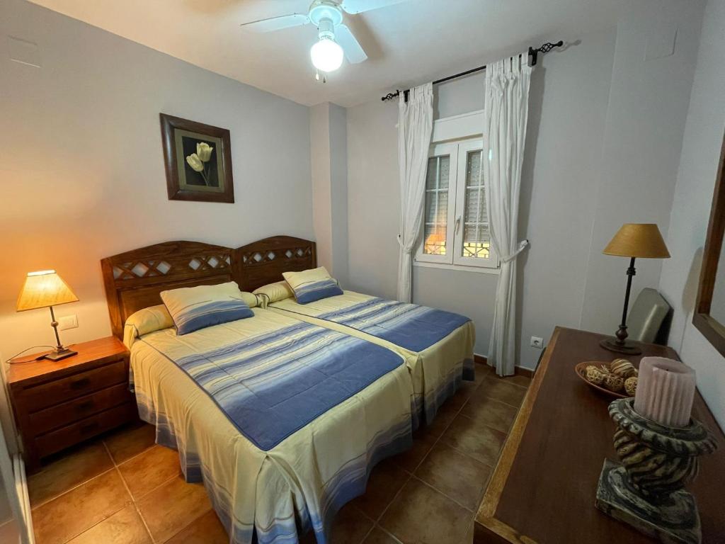 sypialnia z łóżkiem, stołem i oknem w obiekcie Apartamento Deluxe Vistas Laterales al Mar w mieście Isla Canela