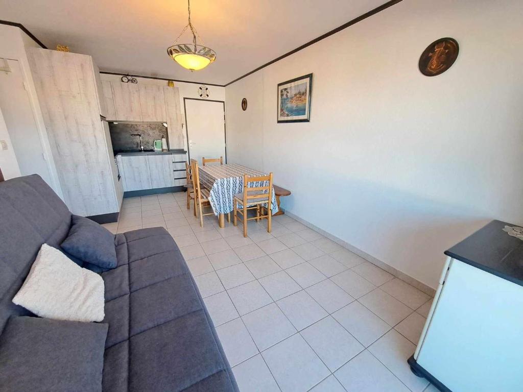 un salon avec un canapé et une table dans l'établissement Appartement 2 pièces climatisé avec balcon, garage et piscine à Marseillan - FR-1-326-707, à Marseillan