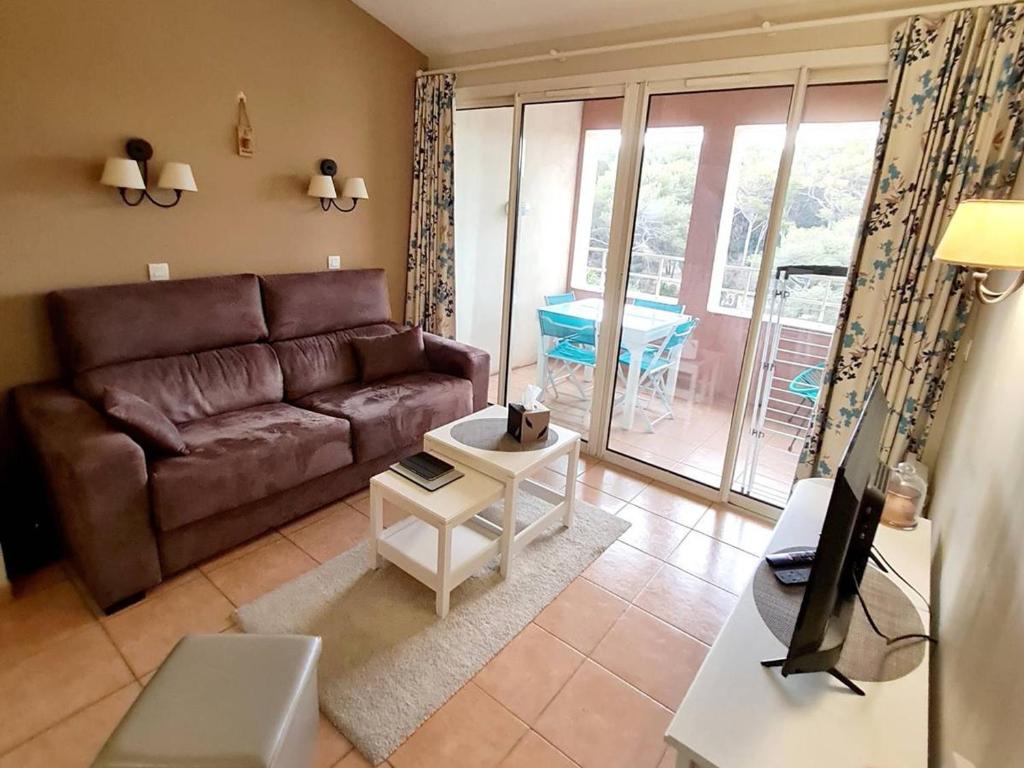 un salon avec un canapé et une table dans l'établissement Appartement T2 + Coin Nuit - Wi-Fi - Piscine Gratuite - Parking Privatif - À 200m Plages et Commerces - FR-1-316-282, à Six-Fours-les-Plages