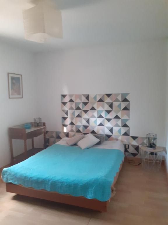 1 dormitorio con 1 cama con cabecero geométrico en CHEZ MAMINE en Castanet-Tolosan