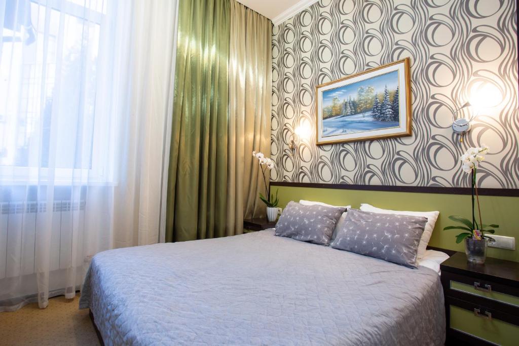 a bedroom with a bed and a picture on the wall at Hotel Voyage in Kharkiv