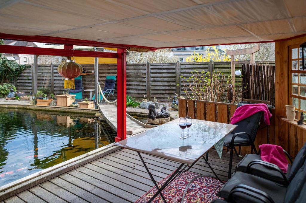 une terrasse avec une table et des chaises à côté d'un étang dans l'établissement Am Teich, à Bützow