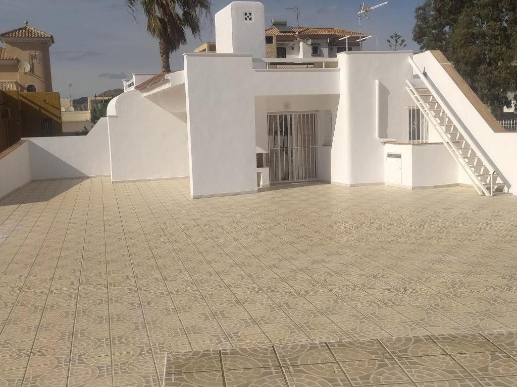 a white house with a tile floor and stairs at PARAÍSO in San Juan de los Terreros