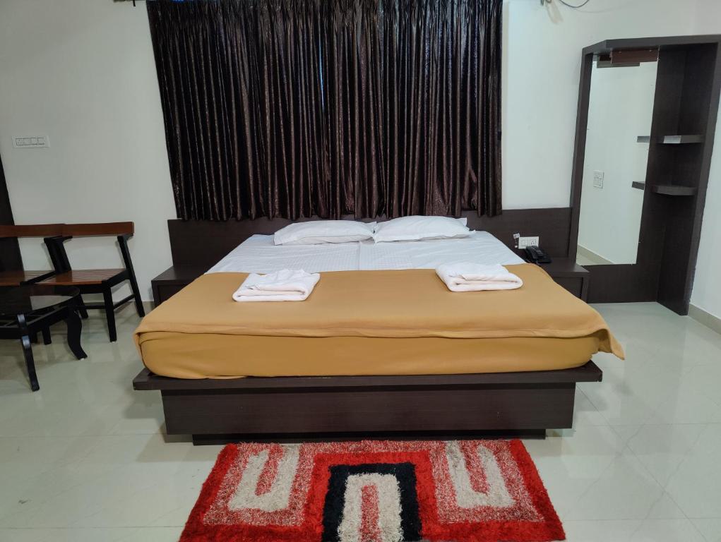 1 dormitorio con 1 cama con 2 toallas en Ratna Sagar, en Udupi
