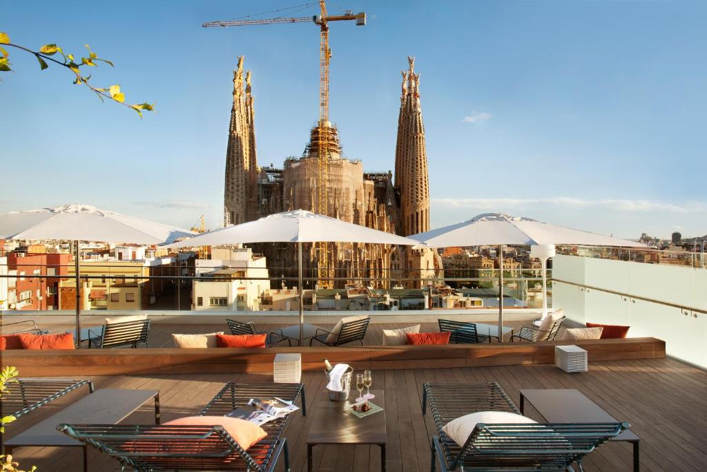 a rooftop patio with tables and chairs and a view of the city at Sercotel Hotel Rosellon in Barcelona