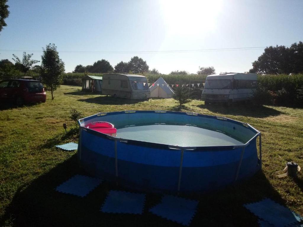 una gran bañera azul en un campo con tiendas de campaña en Campsite with Gypsy Vardo Bell Tent, en Loré