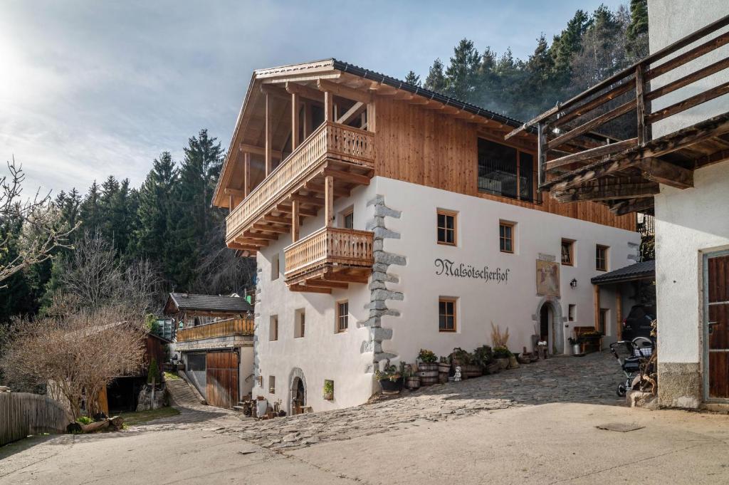 um edifício com uma varanda ao lado em Malsötscherhof Apt C em Villandro