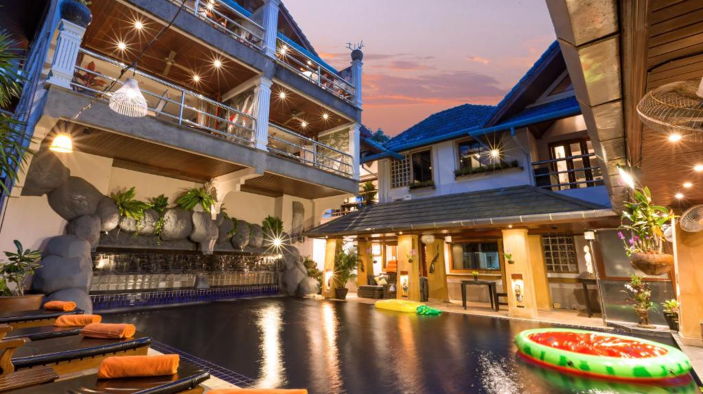 a resort with a pool in the middle of a building at Talay Naiharn Villa in Rawai Beach