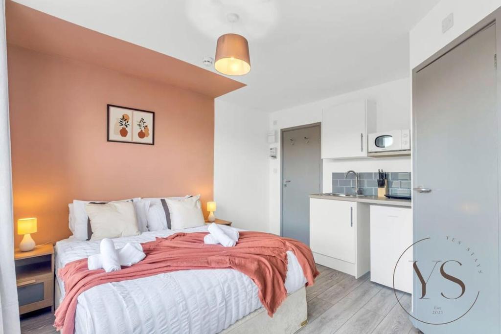 a bedroom with a large bed with orange walls at Gorgeous Longton Studio 2c in Stoke on Trent