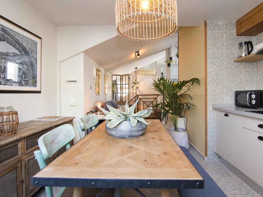 eine Küche und ein Esszimmer mit einem Tisch und einer Pflanze darauf in der Unterkunft Cathedral Cozy Penthouse in Granada