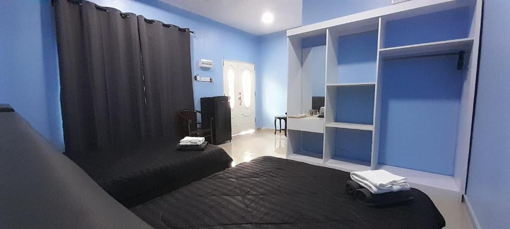 Cette chambre bleue comprend deux lits et un bureau. dans l'établissement Restu Chalet Tioman, à l'Île Tioman