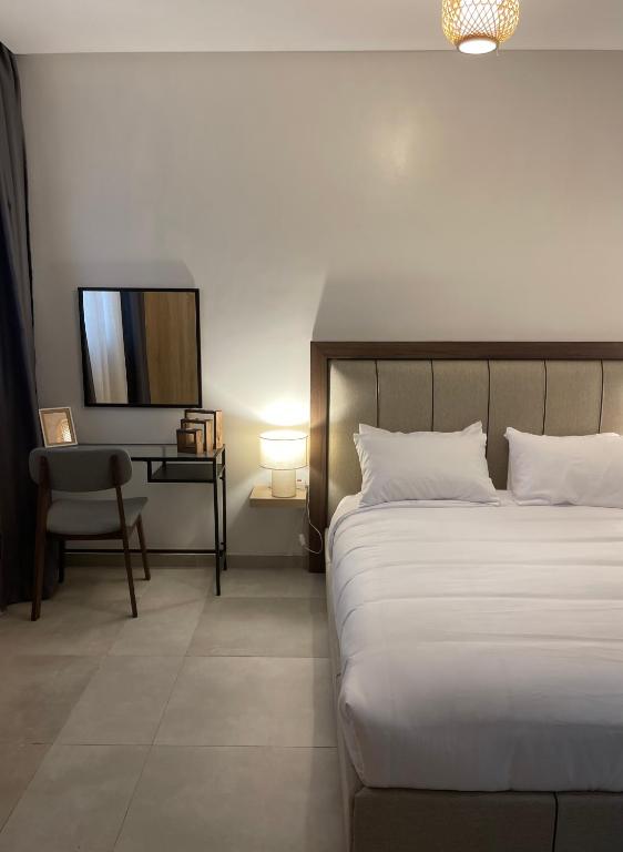 a bedroom with a bed and a chair and a television at Assalama Residency city center by TCE in Agadir