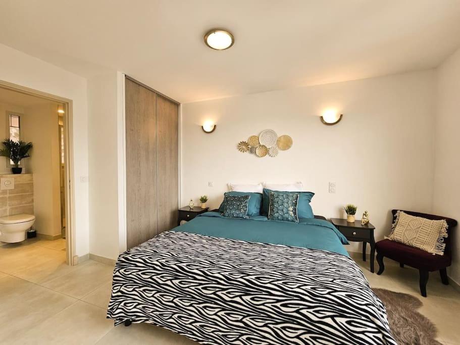 une chambre avec un grand lit et une chaise dans l'établissement A deux pas du centre Historique, à Fréjus