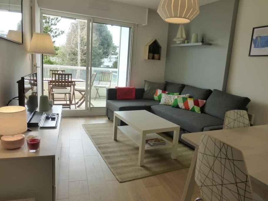un salon avec un canapé et une table dans l'établissement Appartement cosy, vue sur parc, 3 mins plage Benoit, à La Baule