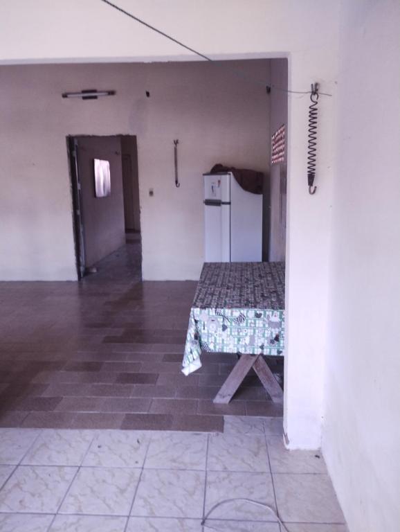 an empty room with a table and a refrigerator at Casa Centro Parajuru in Parajuru