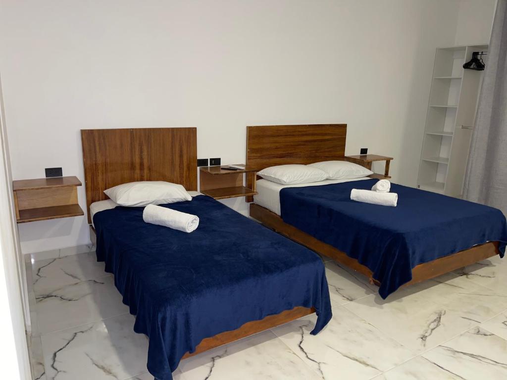 two beds in a room with blue sheets and white pillows at Alce33 in Cancún