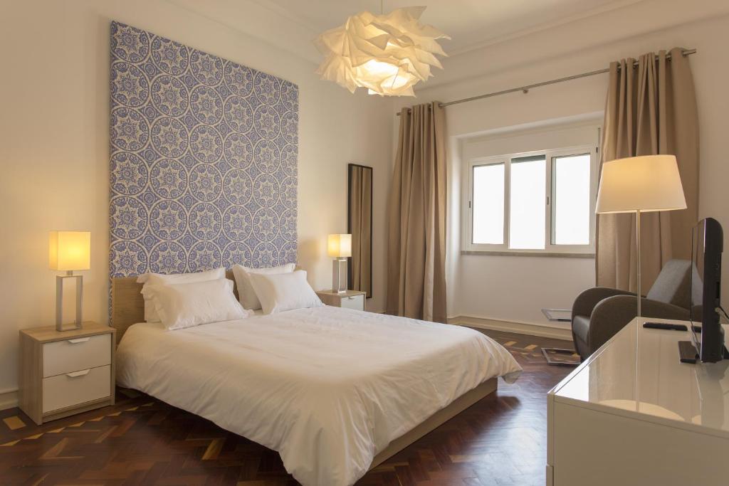 um quarto com uma cama e uma parede azul em Gaspar House em Lisboa