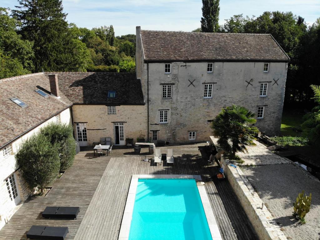 an external view of a house with a swimming pool at LE MOULIN DE TANQUEUX in Cerny