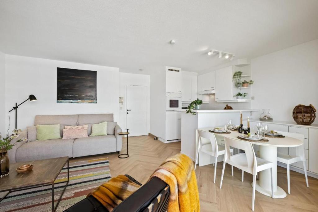 een woonkamer met een bank en een tafel bij Beachday II met garagebox in Nieuwpoort