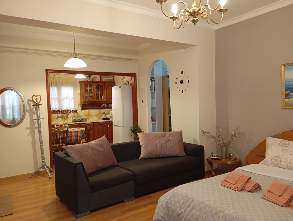 a living room with a couch and a kitchen at Margaritas Cottage in Nafplio