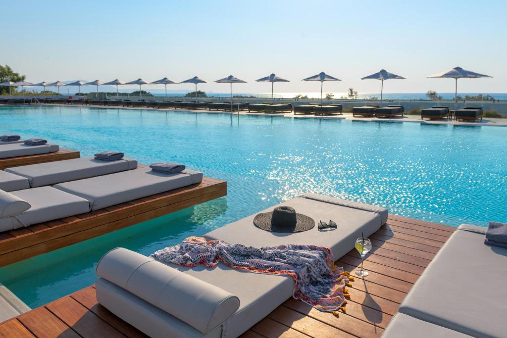 - une piscine avec chaises longues et parasols dans l'établissement Gennadi Grand Resort, à Gennadi