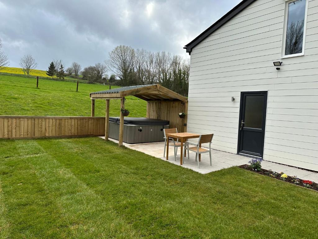 un patio trasero con una mesa de picnic y una parrilla en Springwell Lodge, en Exeter