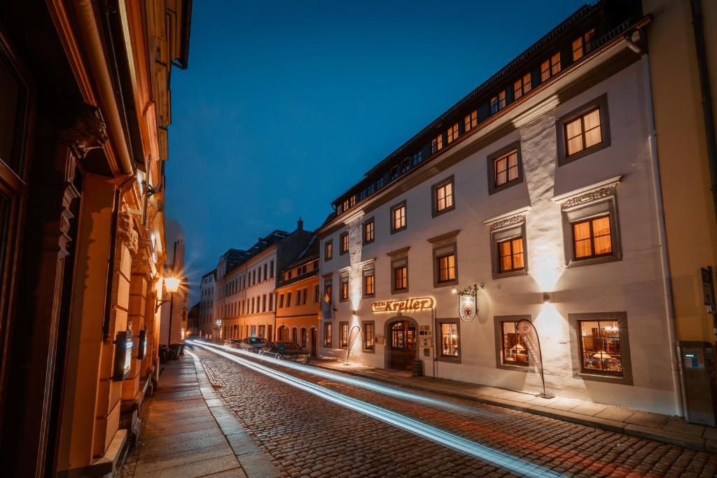 an empty city street at night with buildings at Hotel Kreller in Freiberg