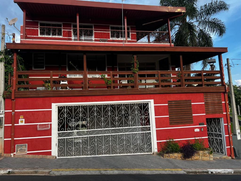 un edificio rojo con una puerta delante de él en Loft família moraes, en Serra Negra