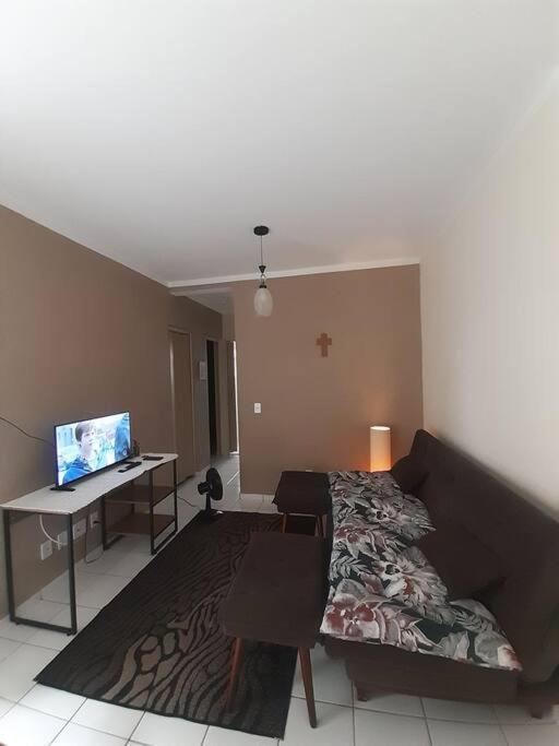 ein Wohnzimmer mit einem Sofa und einem Schreibtisch mit einem Computer in der Unterkunft Cantinho Andorinhas in Campinas