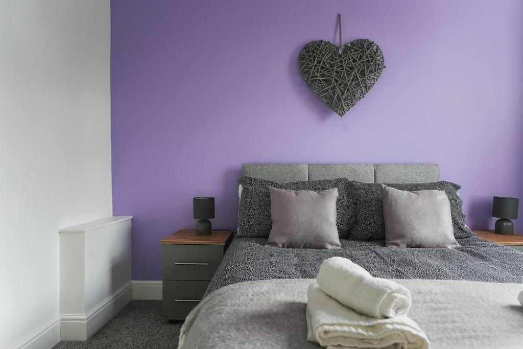 a purple bedroom with a bed with a heart on the wall at Spacious 5-Bed house Private Parking in Newark-on-Trent