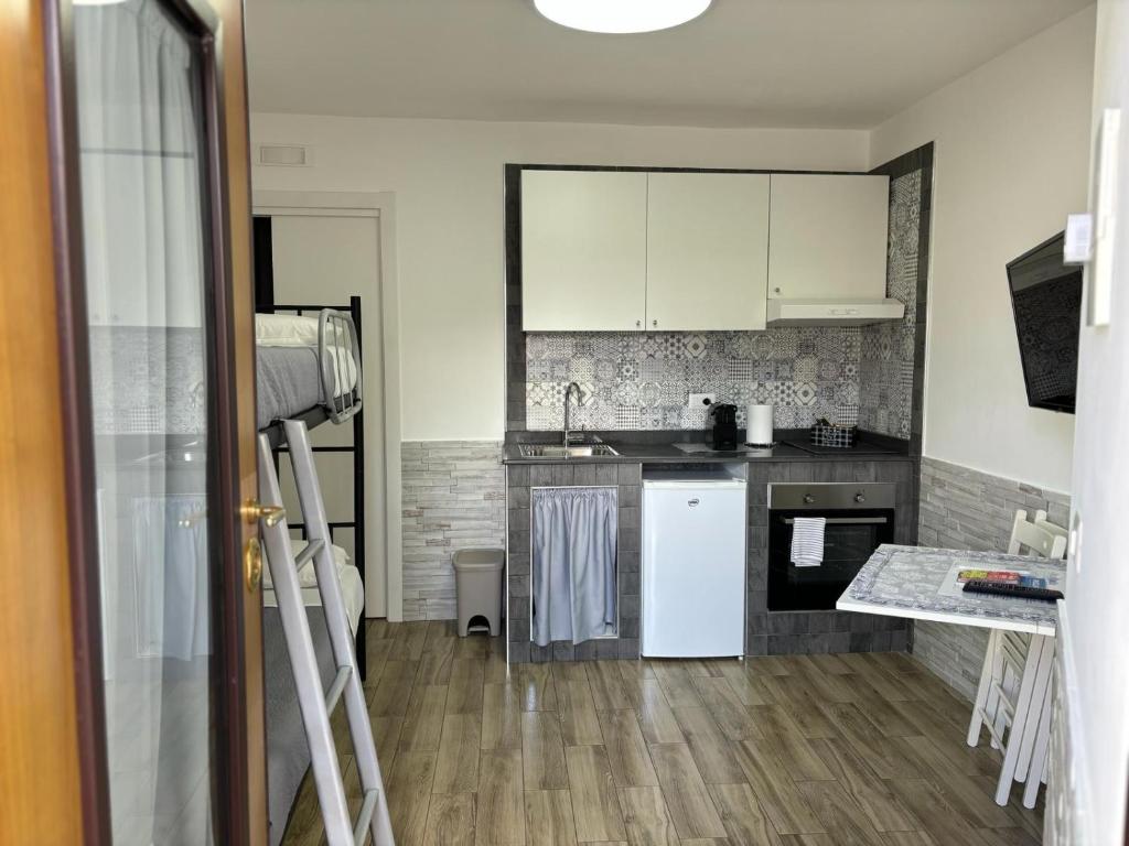 a kitchen with white cabinets and a wooden floor at Truly Apulia in Bari
