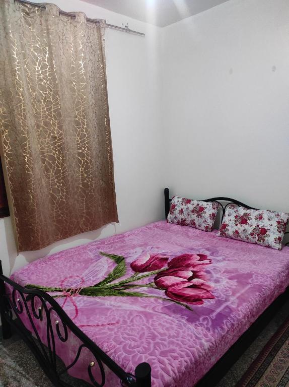 ein Schlafzimmer mit einem rosa Bett mit Rosen darauf in der Unterkunft Appartement situé à 5 minutes à pied de l'Aeroport de Marrakech in Marrakesch