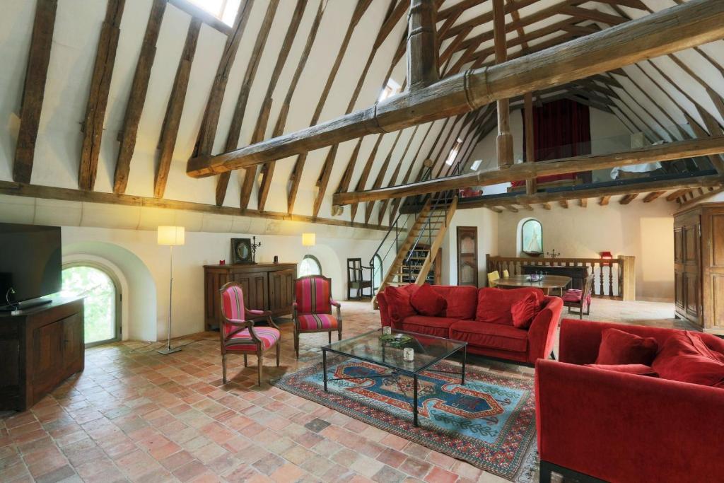 a living room with red couches and a tv at 184 Walvein - EGLISE in Tours