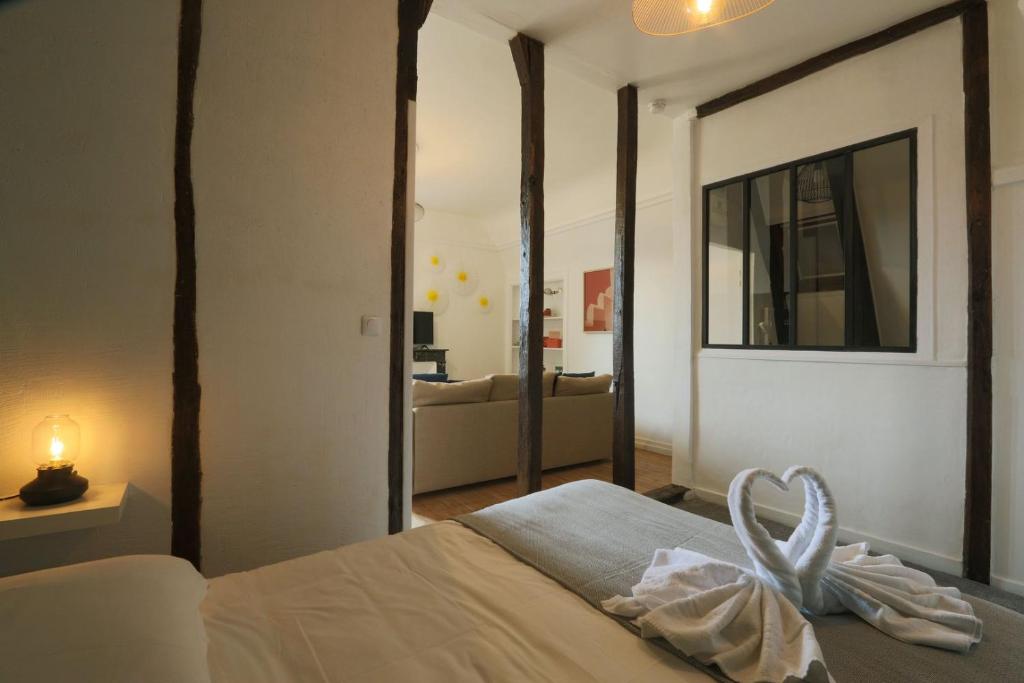 une chambre avec un lit avec une serviette dessus dans l'établissement Let's take a walk in the woods, à Tours