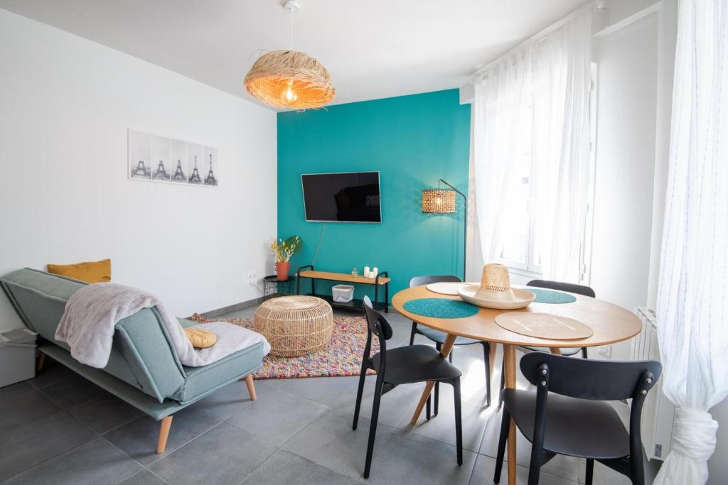 uma sala de estar com uma mesa e uma parede azul em Comfort and modernity in a townhouse em Tours