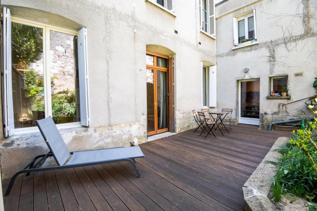 an outdoor deck with a table and chairs at In the heart of silence - Nice house in Tours