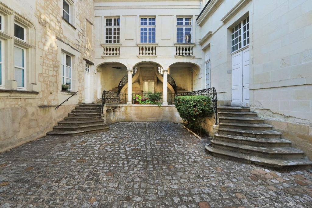 an empty courtyard of a building with stairs at Exceptional location L'Hôtel des Gouverneurs in Chinon