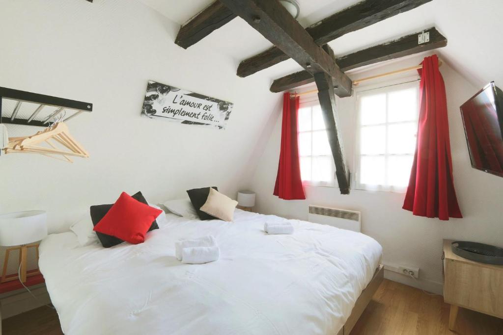 een slaapkamer met een wit bed en rode gordijnen bij Charmant Studio authentique#Tours#PlacePlumereau in Tours