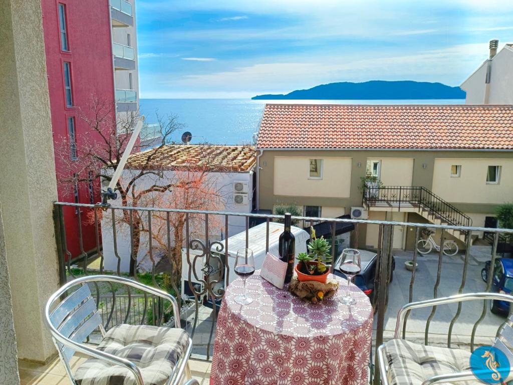uma varanda com uma mesa e cadeiras e o oceano em Amisos Boutique Hotel em Bečići
