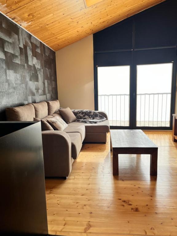 ein Wohnzimmer mit einem Sofa und einem Couchtisch in der Unterkunft Can Bernades in Puigcerdà