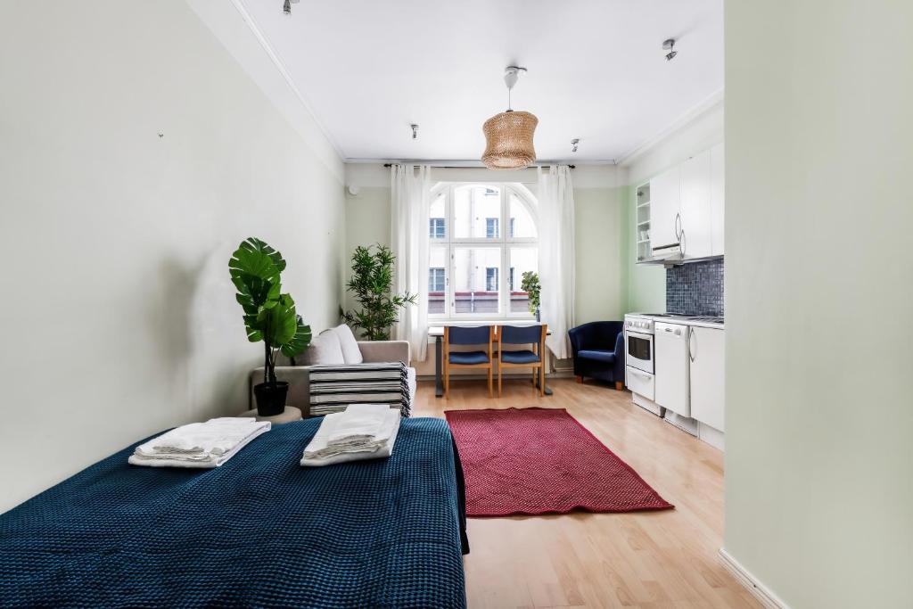 uma sala de estar com uma cama e uma cozinha em Centrum - Lovely furnished Studio em Helsinque