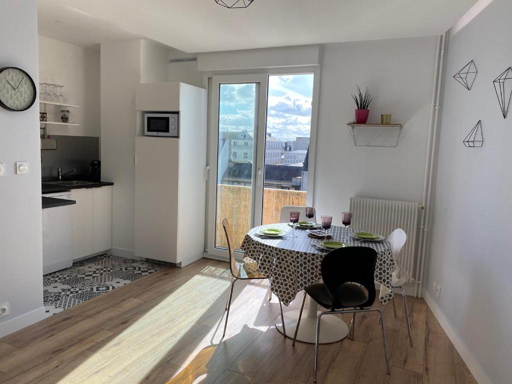 une cuisine et une salle à manger avec une table et des chaises dans l'établissement Lumineux T2 situé dans l'hyper centre de Tours, à Tours
