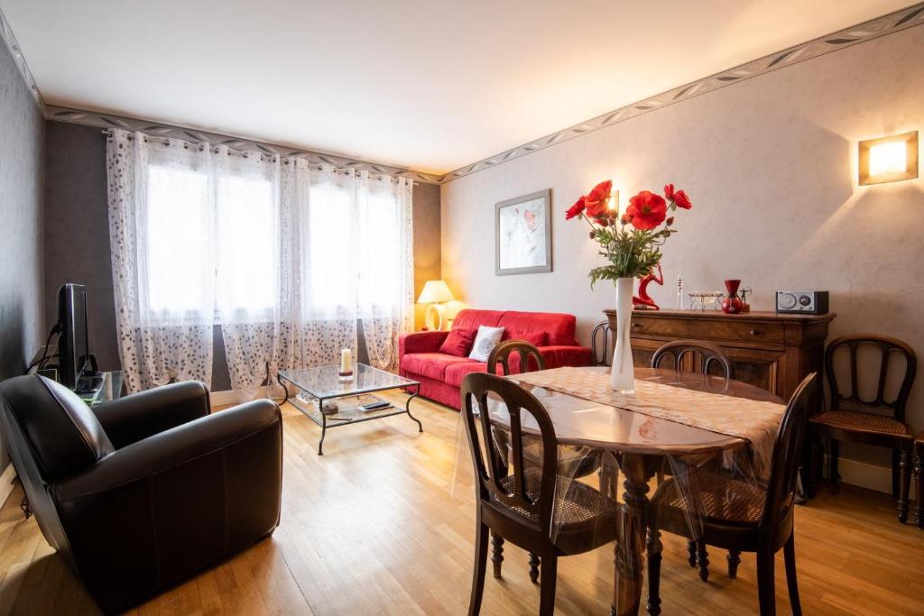 ein Wohnzimmer mit einem Tisch und einem roten Sofa in der Unterkunft In red and black - Nice flat in Tours in Tours