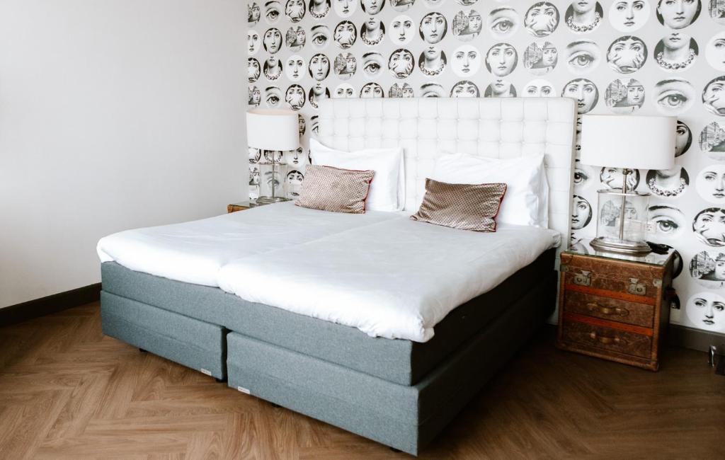 a bedroom with a bed and a wall with plates at Hotel New York by WestCord in Rotterdam