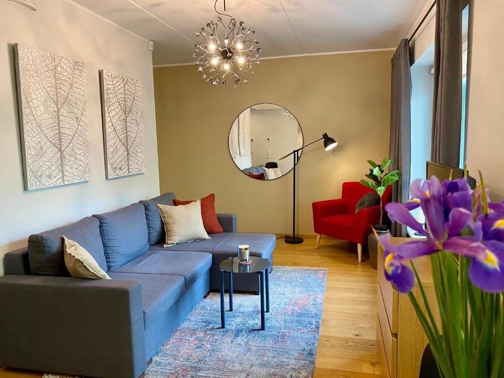 uma sala de estar com um sofá azul e um espelho em Cozy Residence Apartment - Tallinn City Center em Talin