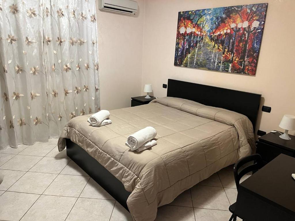1 dormitorio con 1 cama y una pintura en la pared en B&B PIAZZA KOLBE en Acquaviva delle Fonti