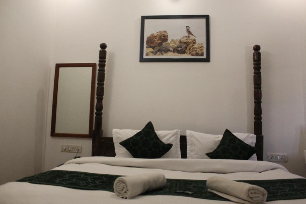 two beds with pillows and a mirror on the wall at Hotel Dara & Camel Safari in Jaisalmer