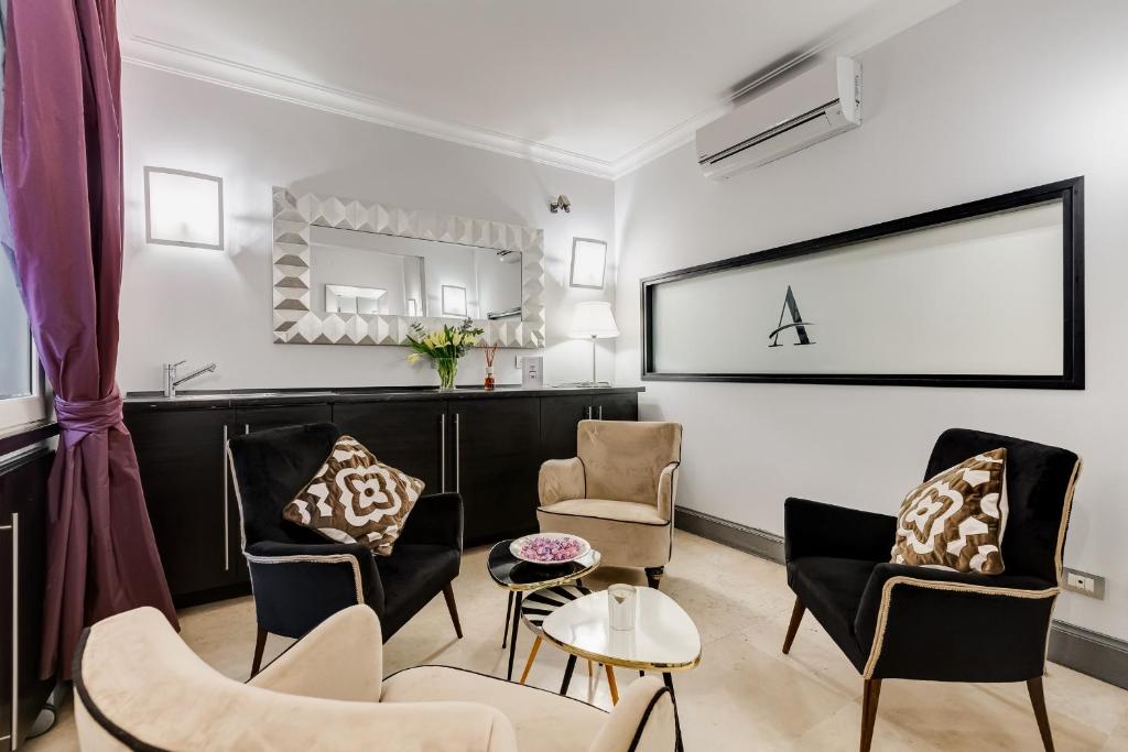 a living room with chairs and a table at Residenza A -Via Veneto Fashion Rooms -self check-in in Rome