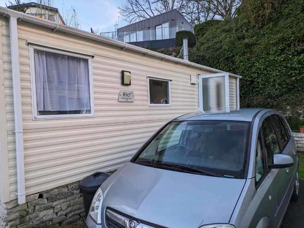 a car is parked in front of a house at Homely 2 bed caravan sleeps 4 5 in Portland Dorset in Portland